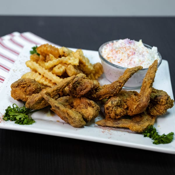 Detroit Soul's fried chicken wings and crinkle-cut fries with a side of coleslaw.