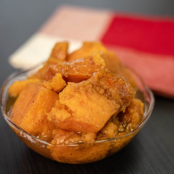 A clear bowl of Detroit Soul's candied yams, glistening with syrup and spices.